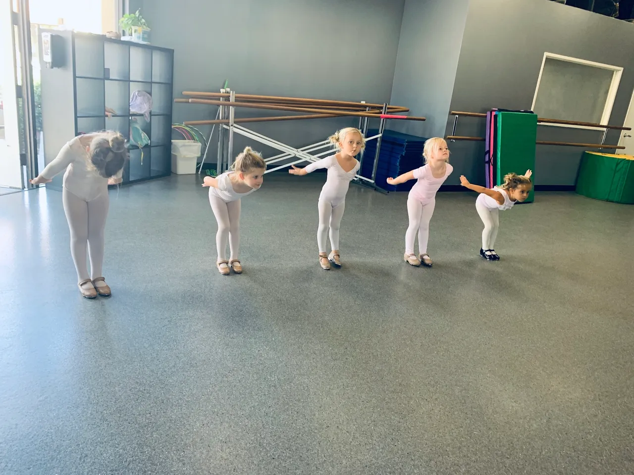 A group of young children in white outfits practicing.