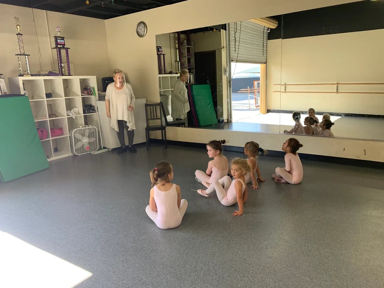 A group of children sitting in front of an instructor.