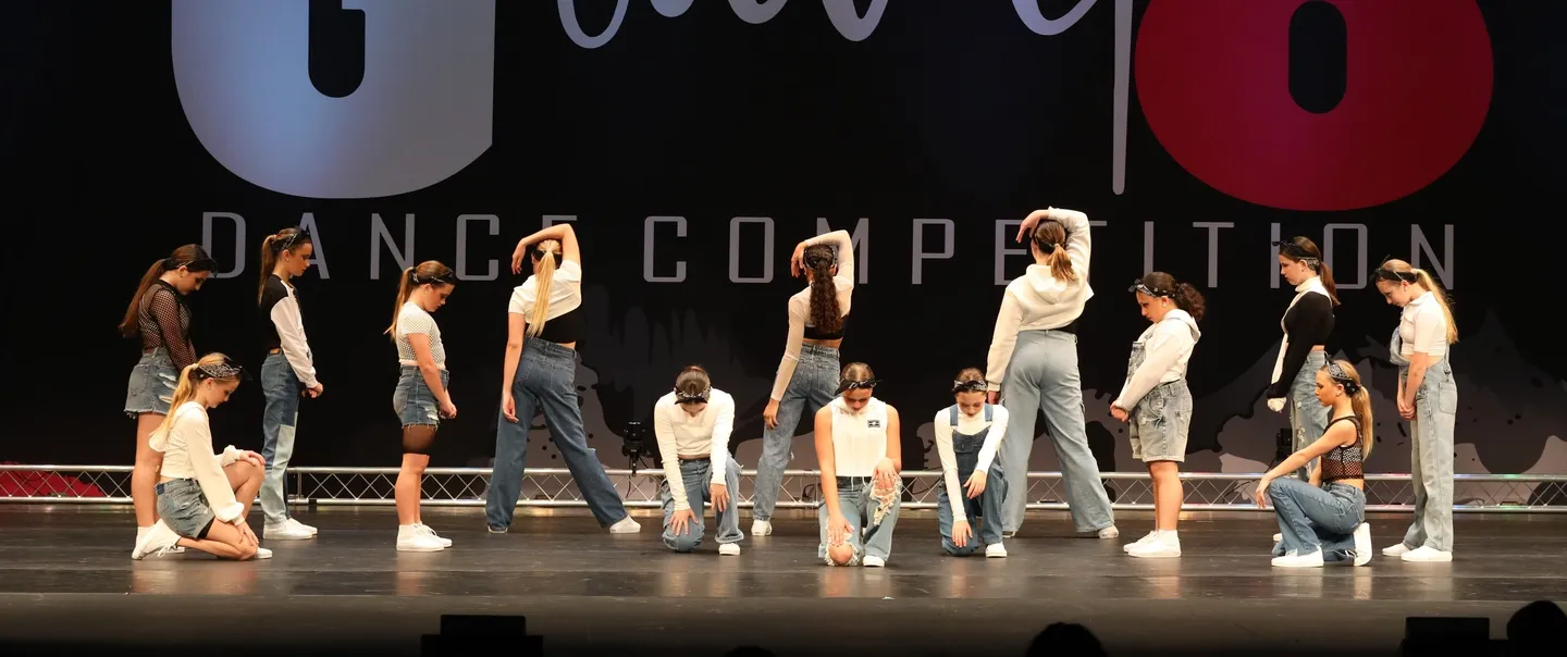 A group of people on stage performing dance moves.