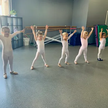 A group of young children in white outfits doing different exercises.