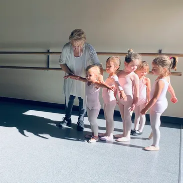 A group of young children in ballet outfits.